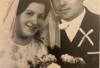 Czarno-biała fotografia zdjęcia weselnego z młodą parą i bukietem kwiatów