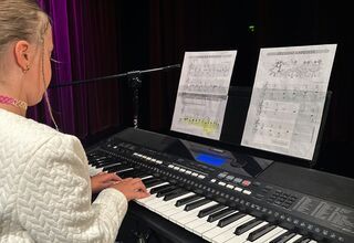 Zdjęcie: dziewczynka w białej marynarce, grające na keyboardzie