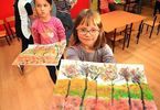 Dwie dziewczynki prezentują prace plastyczne z drzewami