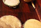 Instrumenty na drewnianym blacie berimbau i   trzy pandeiro