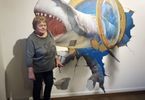 Kobieta pozuje na tle muralu rekina