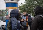 Grupa ludzi stoi na parkingu