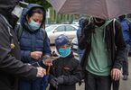 Chłopczyk i dorosłe osoby stoją w deszczu