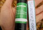 Zbliżenie na dłoń. Na niej położony przedmiot do zabawy geocaching.