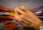 Zdjęcie przedstawiające dłoń malującą farbami akrylowymi