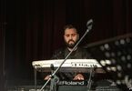 Mężczyzna z brodą gra na pianinie elektronicznym