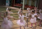 Dziewczynki w różowych spódnicach w pozie tanecznej, z  tyłu lustra