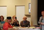 Seniorzy siedzą przy stole wielkanocnym