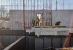 Pracownicy budowy na ścianie żelbetonowej