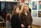Trzy dziewczynki patrzące na obrazy i zwiedzające wystawę