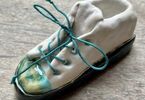 Biały ceramiczny but z zielonymi sznurówkami