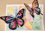 Zdjęcie: dwa trójwymiarowe, kolorowe motyle na pomalowanej kartce A3