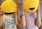 Zdjęcie: dwie dziewczynki trzymające na twarzy poduszki, żółte emotki