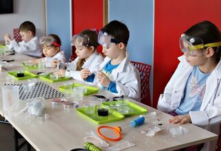 Dzieci przy stoliku podczas eksperymentów